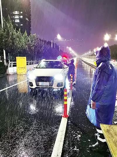 凌晨，東甌大橋卡點處，永嘉縣黨員干部頂風(fēng)冒雨、在嚴(yán)寒中牢牢值守。（　圖片由浙江省溫州市委組織部提供）